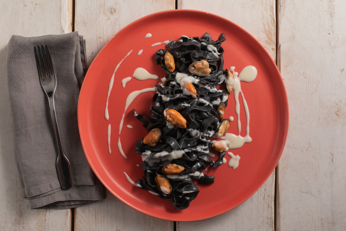 Tagliatelle à l'encre de seiche avec pecorino, moules et lard