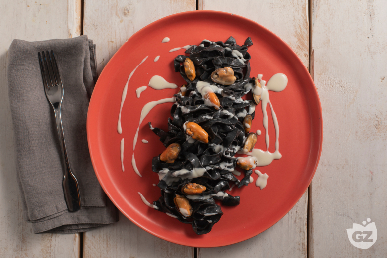 Tagliatelle à l'encre de seiche avec pecorino, moules et lard