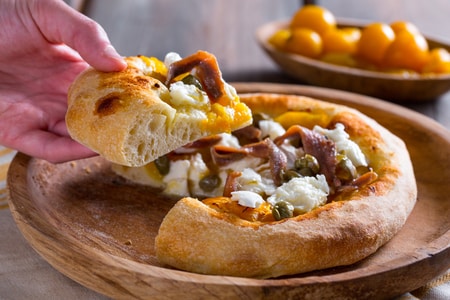 Pizza aux tomates cerises jaunes, anchois et câpres