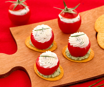 Pain plat avec tomates cerises farcies au fromage et roquette