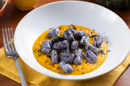 Gnocchis de pommes de terre violettes avec crème de potiron et chou noir