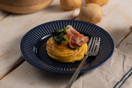 Nids de pommes duchesse avec des pousses de brocoli-rave