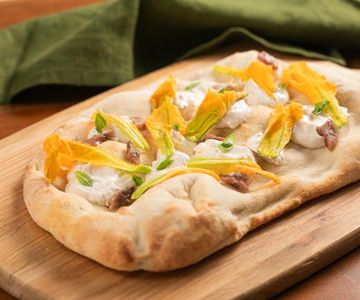 Pinsa aux fleurs de courgette, anchois et crème au fromage