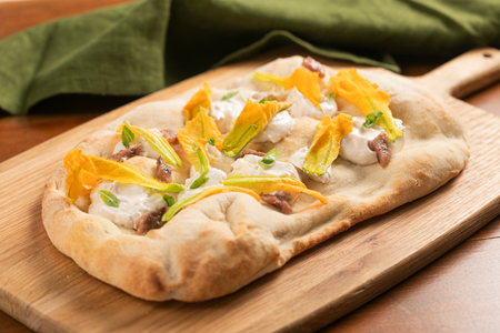 Pinsa aux fleurs de courgette, anchois et crème au fromage