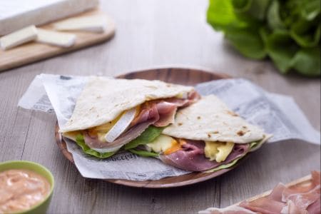 Piadina avec jambon cru, brie, salade et sauce cocktail