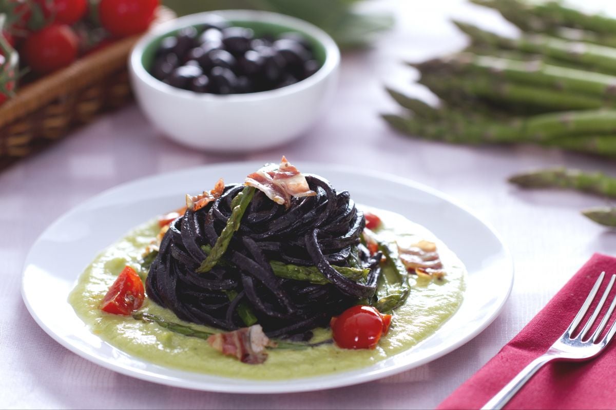 Spaghetti à la guitare à l'encre d'olive avec asperges et lardons